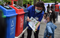 5月23日，垃圾分类指导员向孩子介绍指导手册上的垃圾分类小知_076531.jpg