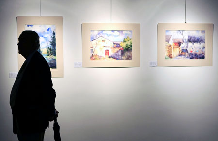 Un visiteur admire les oeuvres de la peintre chinoise Chen Luojia lors de l&apos;ouverture de l&apos;exposition d&apos;aquarelles et de lavis d&apos;encre de Chine qui a eu lieu mardi à Paris et qui a attiré de nombreux visiteurs chinois et français de divers milieux.