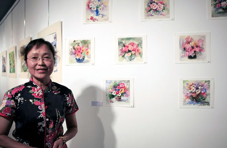 La peintre chinoise Chen Luojia présente ses oeuvres lors de l&apos;ouverture de l&apos;exposition d&apos;aquarelles et de lavis d&apos;encre de Chine qui a eu lieu mardi à Paris et qui a attiré de nombreux visiteurs chinois et français de divers milieux. 