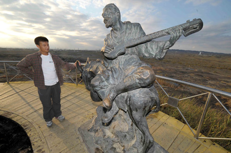  Un touriste visite dimanche une statue sur la montagne de l'Huile noire à Karamay.